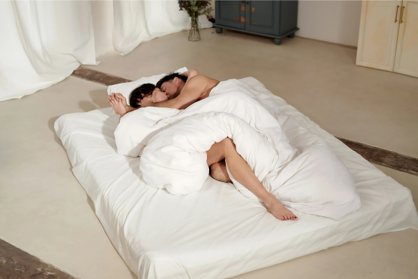 Coppia felice sotto le coperte: complicità perfetta per provare la posizione del cucchiaio