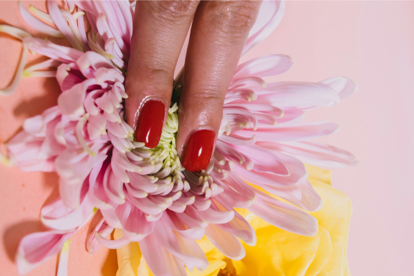 Rituale Yoni rappresentato da una mano che sfiora un fiore, simbolo di sacralità del corpo femminile