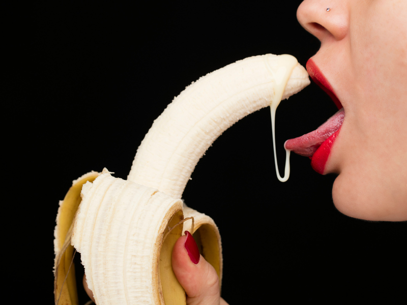 Donna con una banana in mano, sporca di crema: immagine ironica per parlare dei benefici dell’ingoiare sperma